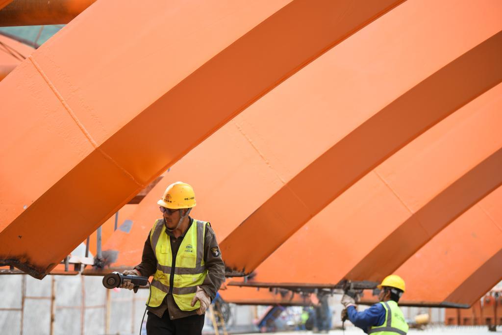 5月31日,工人在陕西东庄水利枢纽泾河大桥施工现场工作。