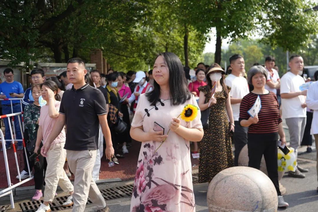 家长手拿寓意着“一举夺魁”的向日葵，为考生送上祝福。