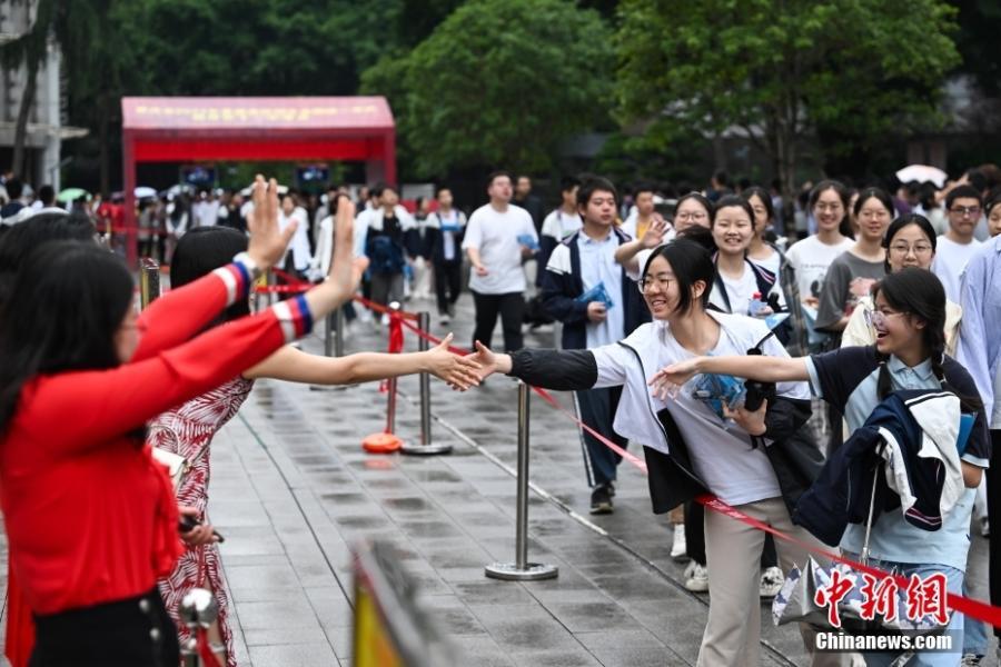 6月7日，重庆市第十一中学校考点，老师为进入考场的考生加油鼓劲。当日，2024年全国高考拉开帷幕。中新社记者 何蓬磊 摄