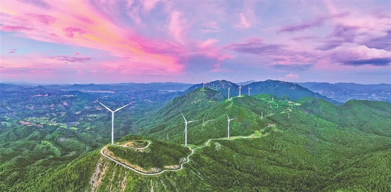 在安远县九龙山风力发电场,一台台风力发电机屹立在山巅,叶片随风旋转