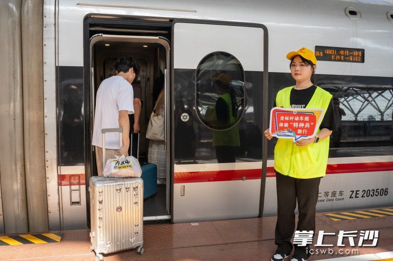 志愿者手持宣传板供乘车旅客打卡纪念。