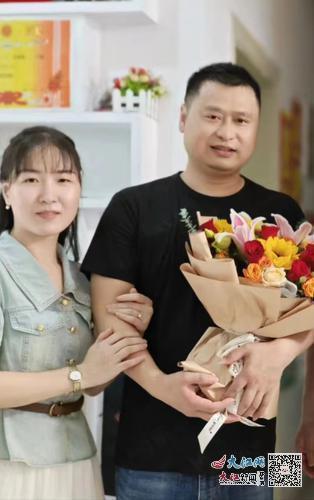 手捧单位慰问时送来的鲜花,吴满申与妻子合影。