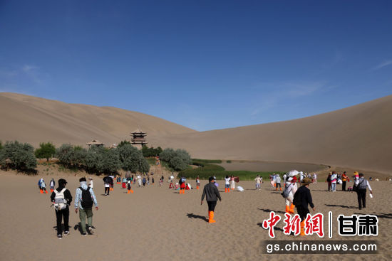 端午假期,众多游客走进甘肃省敦煌市鸣沙山月牙泉景区欣赏大漠风光,体验丝路风情,欢度端午佳节。张晓亮 摄