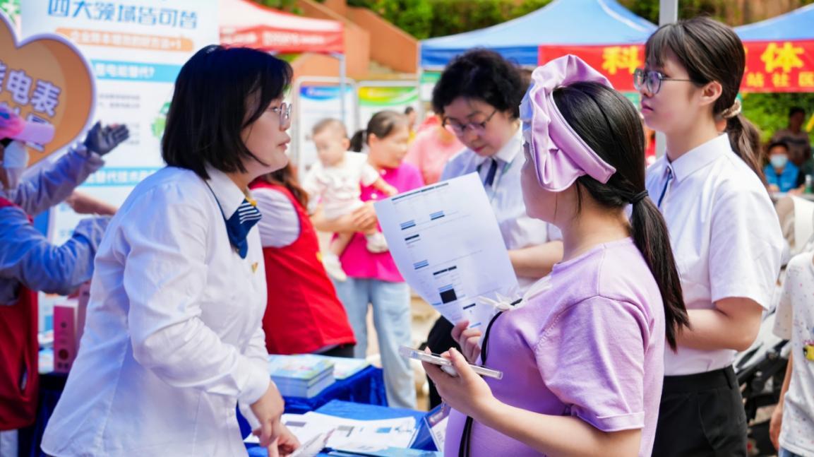 （南方电网深圳龙华供电局社区经理向居民宣传社区服务“十办”新举措。摄/通讯员 刘晓莎）
