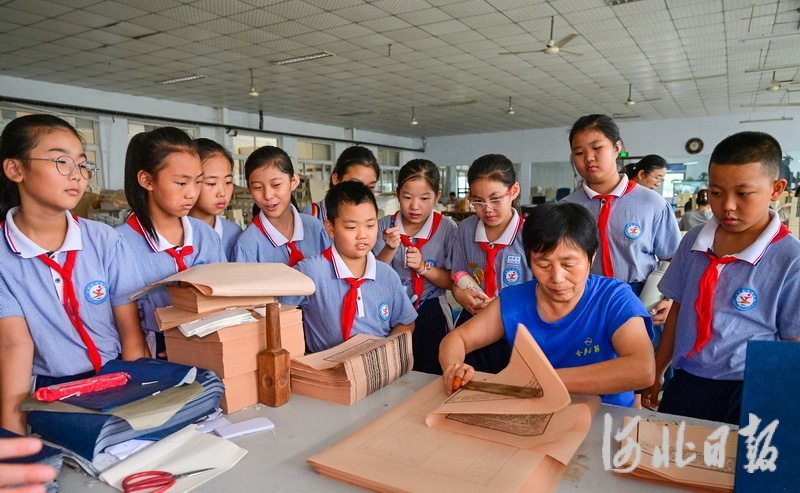 6月21日，吴桥县实验小学的学生在了解线装书制作技艺。