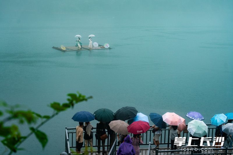 东江湖上的表演引来游客们纷纷驻足。