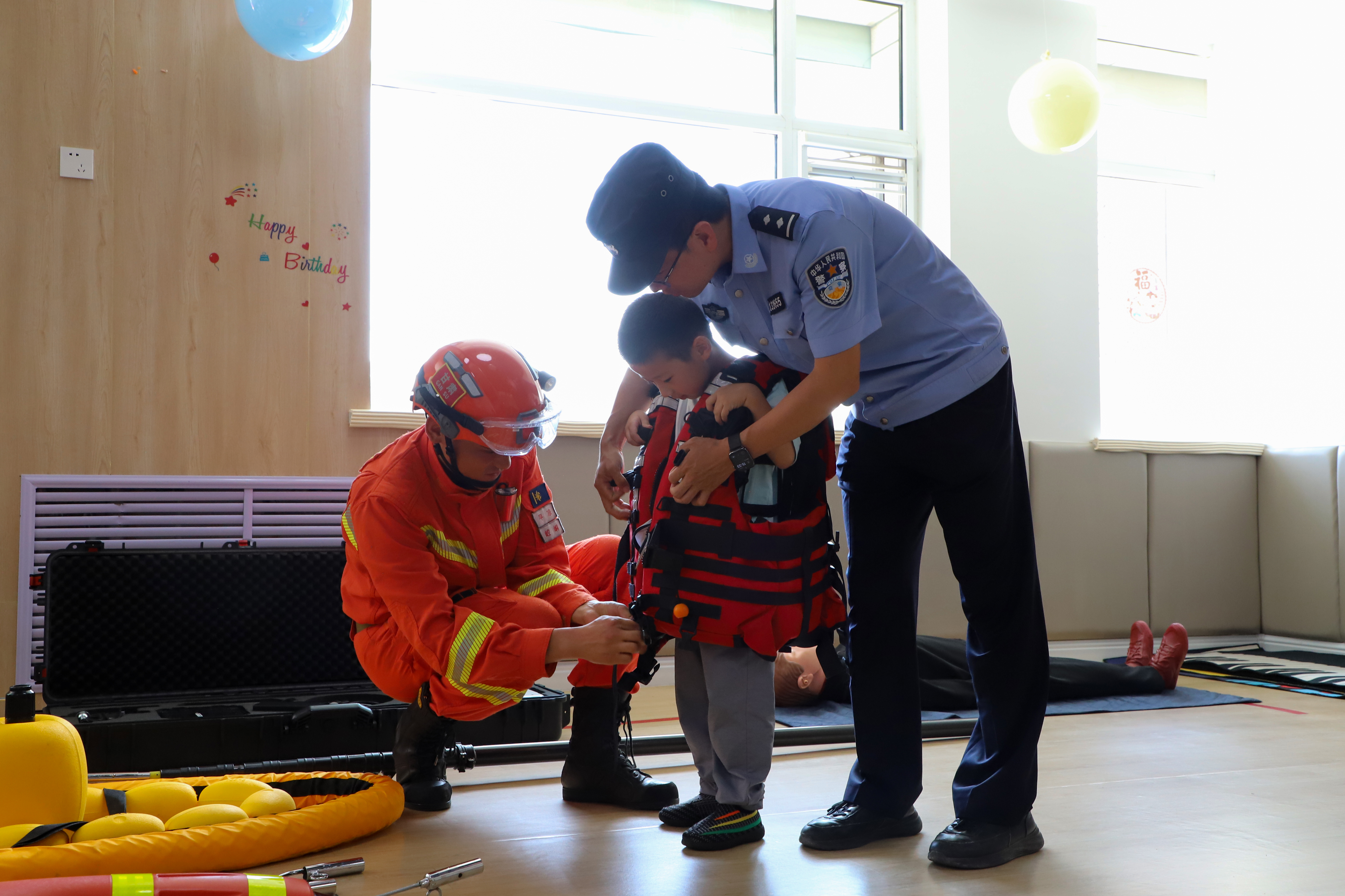 消防员和公安民警为小朋友演示救生衣穿戴