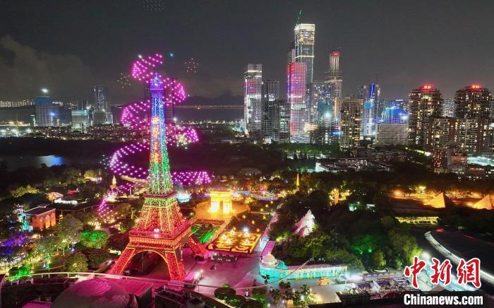 图为无人机在深圳世界之窗埃菲尔铁塔和凯旋门上空表演。记者 陈文 摄