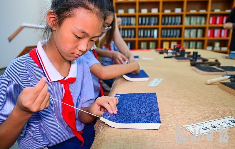 6月21日，吴桥县实验小学的学生在河北线装书博物馆体验缝书。