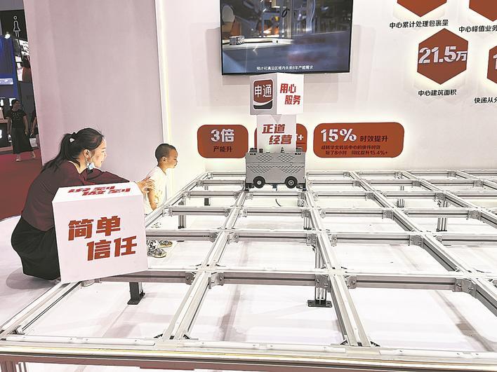 一款顶着几个快递盒的分拣机引来了众多好奇的目光。本报记者 李丽钧 摄