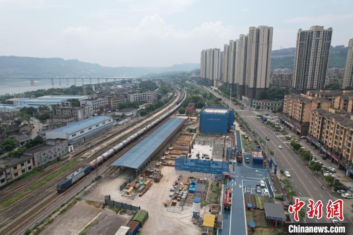 6月14日，成渝铁路江津站，在驶过的列车旁，扩能工程已做好准备。岳鹏勇 摄
