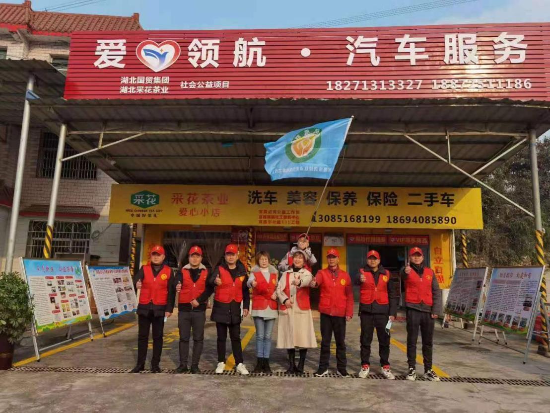 “点亮公益”的同伴们在洗车店门口合影