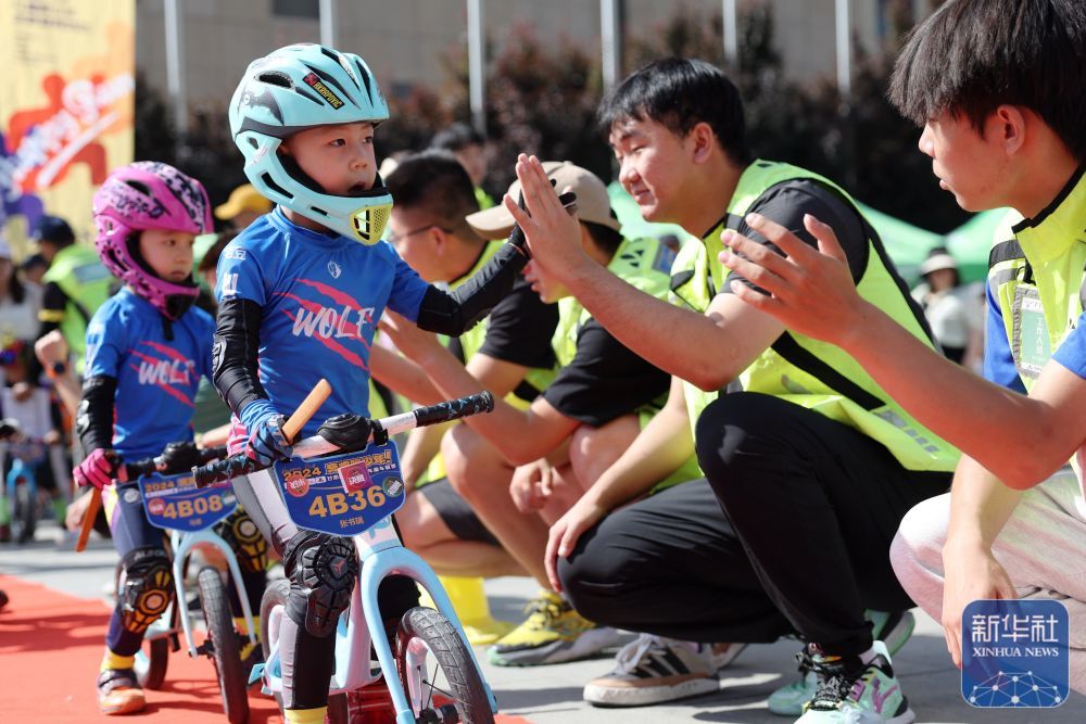 ↑小选手张书瑞（前）在比赛入场时与工作人员击掌