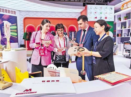 6月17日,在2024年中国·廊坊国际经济贸易洽谈会辛集展馆,辛集市文丽工艺品有限公司负责人陈文丽(右一)正在给客商推介辛集皮贴画。 河北日报通讯员 张大恩摄