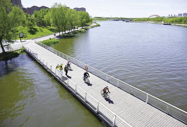 伊通河上,骑行者正在通过水面栈道。