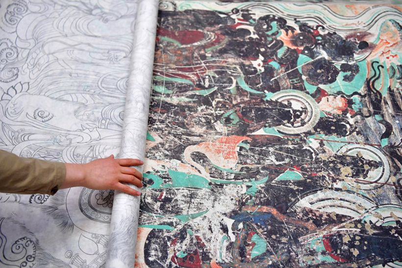 “90后”的刘小同是敦煌研究院美术研究所的一名美术工作者，主要从事敦煌壁画的临摹、研究和创新工作。图为2022年4月18日，刘小同在研究所画室内校对白描稿。新华社记者　陈斌　摄