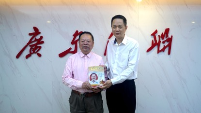 巫金星会长为中国侨联副主席,广东省侨联主席李丰赠送榜样书籍
