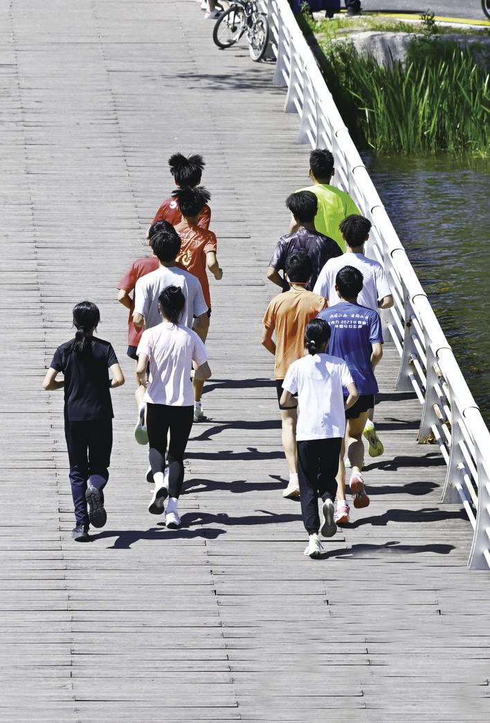 一群充满朝气的年轻人正奔跑在洒满阳光的栈道上。