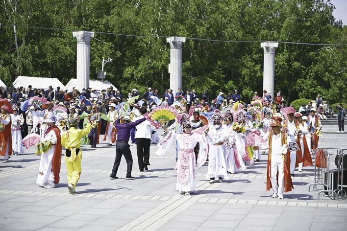 公园的广场上,东北大秧歌吸引了外地游客驻足观看。