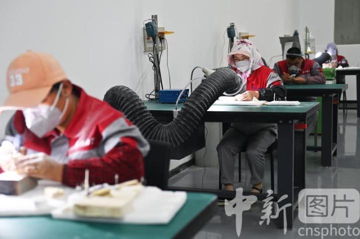 7月4日，位于甘肃省临夏县的甘肃临丰骨艺科技文化公司展厅内，工作人员进行骨雕制作。该公司专业从事骨雕文化研究与技艺传承，以当地牛骨羊骨等为原材料进行雕刻创作，产品涵盖具有临夏文化符号的伴手礼、骨瓷礼、家具装饰、乐器配件、文玩把件、生活器皿等骨雕系列产品，年产各类骨雕艺术品2万多件，实现牛骨羊骨“变废为宝”，延伸了当地牛羊产业发展链条。 中新社记者 李亚龙 摄