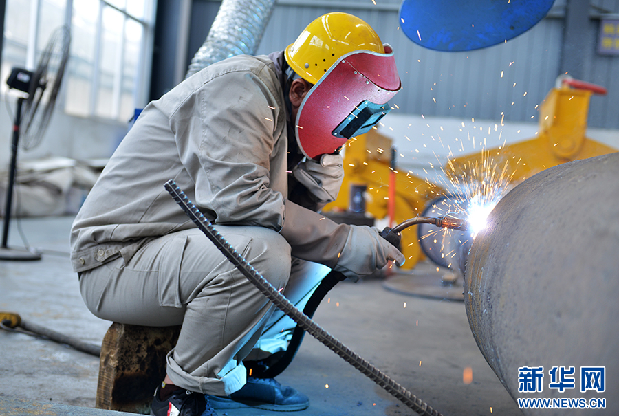 7月2日,在河南济源钢铁(集团)有限公司生产车间,工人正在焊接钢制品。