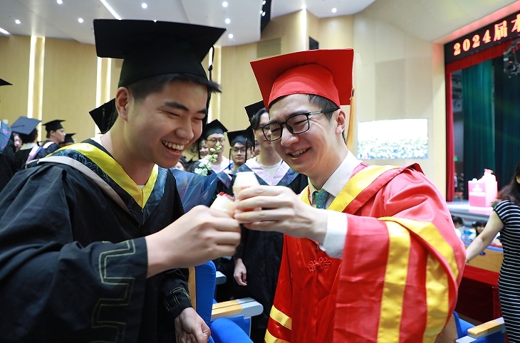 毕业生与学校董事长喻恺共举乳酸菌“干杯”