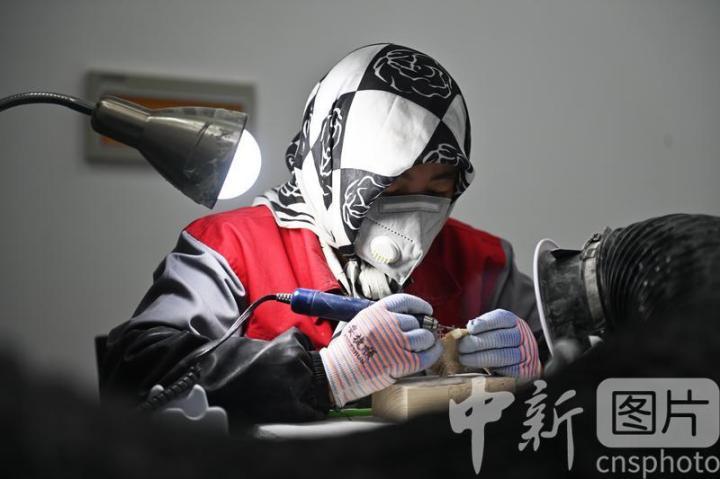 7月4日，位于甘肃省临夏县的甘肃临丰骨艺科技文化公司展厅内，工作人员进行骨雕制作。该公司专业从事骨雕文化研究与技艺传承，以当地牛骨羊骨等为原材料进行雕刻创作，产品涵盖具有临夏文化符号的伴手礼、骨瓷礼、家具装饰、乐器配件、文玩把件、生活器皿等骨雕系列产品，年产各类骨雕艺术品2万多件，实现牛骨羊骨“变废为宝”，延伸了当地牛羊产业发展链条。 中新社记者 李亚龙 摄