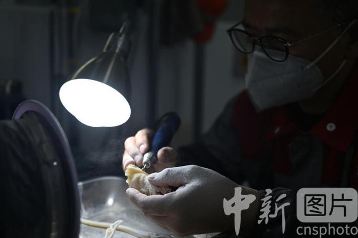 7月4日，位于甘肃省临夏县的甘肃临丰骨艺科技文化公司展厅内，工作人员进行骨雕制作。该公司专业从事骨雕文化研究与技艺传承，以当地牛骨羊骨等为原材料进行雕刻创作，产品涵盖具有临夏文化符号的伴手礼、骨瓷礼、家具装饰、乐器配件、文玩把件、生活器皿等骨雕系列产品，年产各类骨雕艺术品2万多件，实现牛骨羊骨“变废为宝”，延伸了当地牛羊产业发展链条。 中新社记者 李亚龙 摄