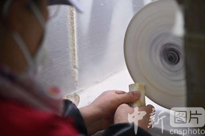 7月4日，位于甘肃省临夏县的甘肃临丰骨艺科技文化公司展厅内，工作人员进行骨雕制作。该公司专业从事骨雕文化研究与技艺传承，以当地牛骨羊骨等为原材料进行雕刻创作，产品涵盖具有临夏文化符号的伴手礼、骨瓷礼、家具装饰、乐器配件、文玩把件、生活器皿等骨雕系列产品，年产各类骨雕艺术品2万多件，实现牛骨羊骨“变废为宝”，延伸了当地牛羊产业发展链条。 中新社记者 李亚龙 摄