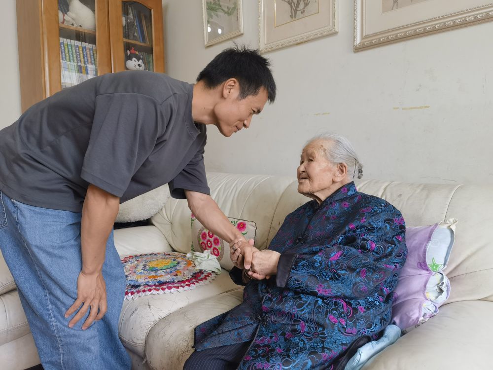 ↑2024年6月24日，四川省都江堰市，老红军王全英（右）同记者握手告别。新华社记者　李秉宣　摄