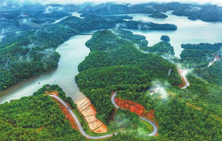 6月18日,鹰潭市余江区画桥镇大桥村,锦北水库烟雨朦胧,车辆行驶在沿线