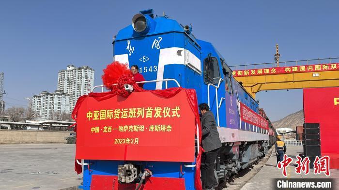 2023年3月25日,首列甘肃定西至哈萨克斯坦的中亚国际货运班列发车现场,工作人员装饰火车头。(资料图)王牧雨 摄