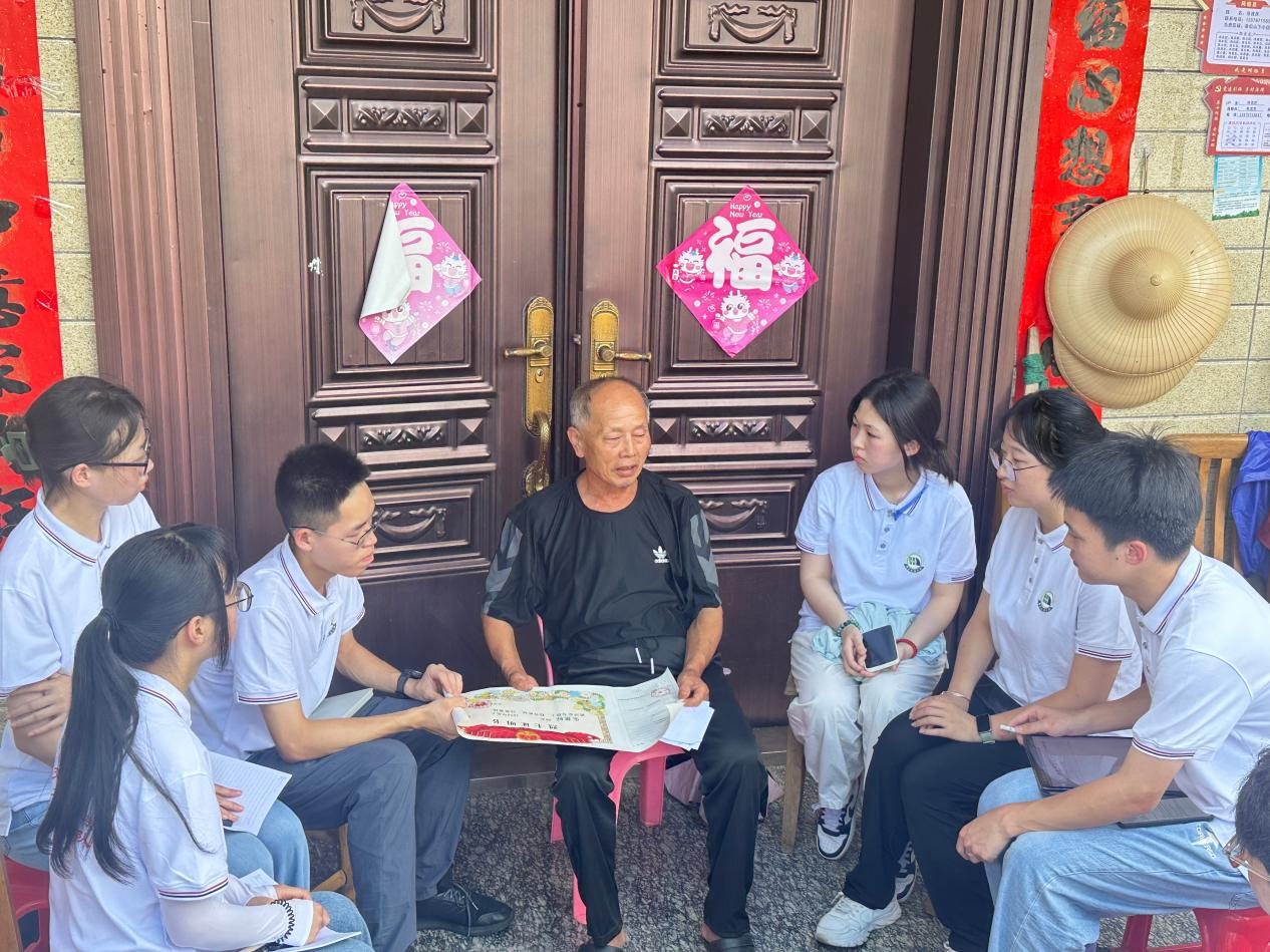朱流庆拿着父亲的烈士证明书给实践队员们讲述父亲的革命故事