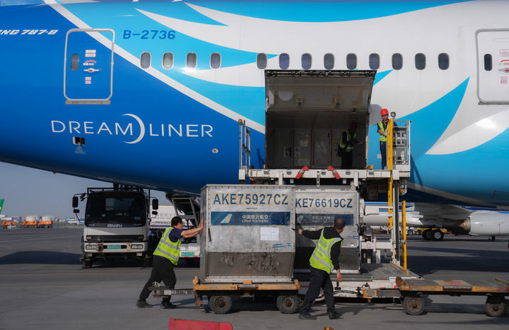 南航工作人员在乌鲁木齐地窝堡国际机场装卸国际航班货物（2024年4月28日摄）。新华社发（车捷 摄）