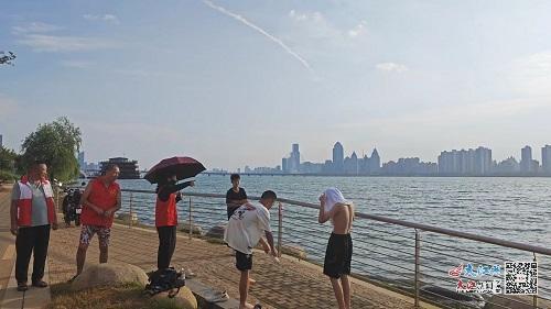 志愿者正在劝导准备嬉水的少年