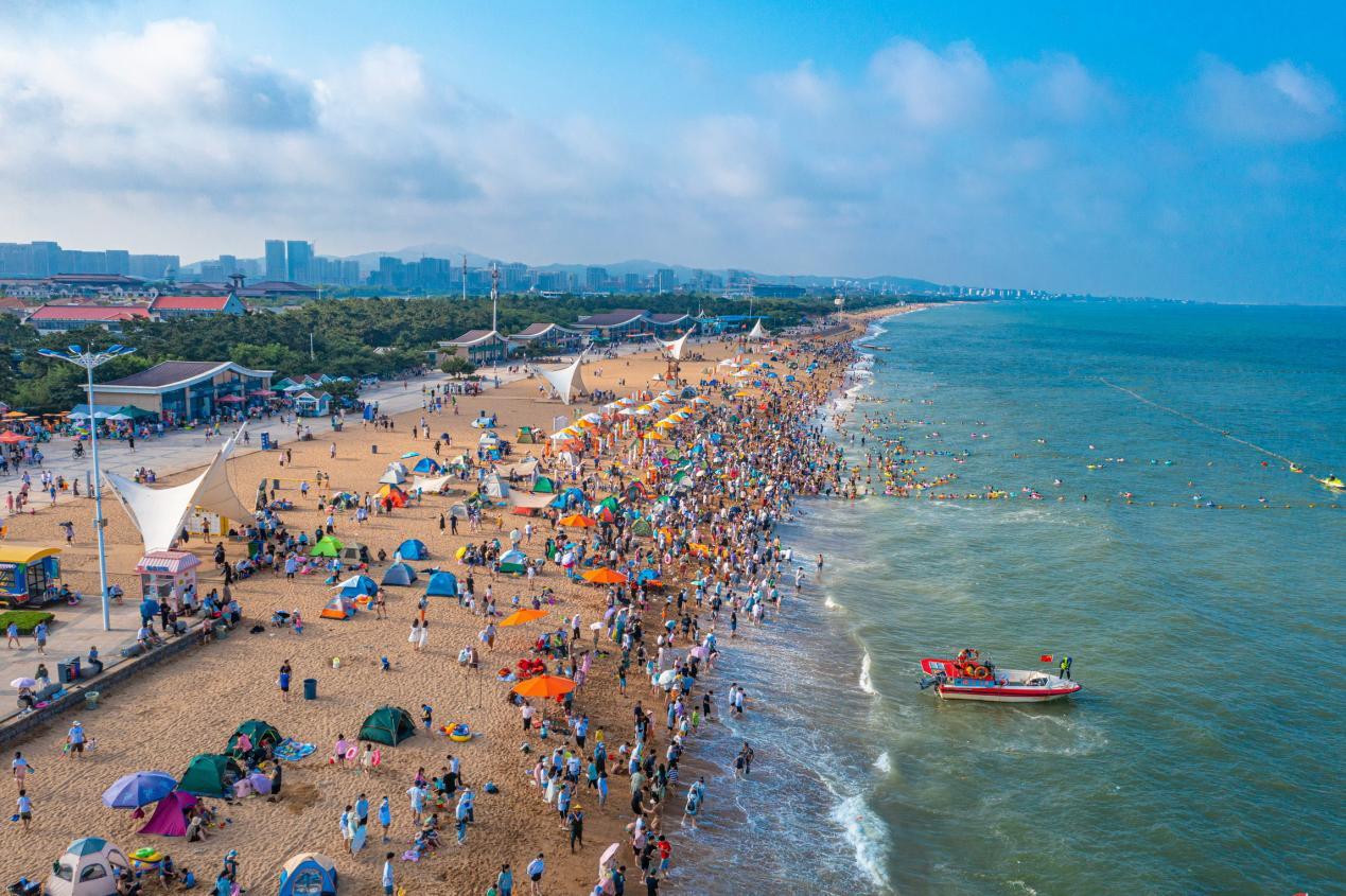 沙滩上人头攒动，游客们如繁星般点缀着这片金色的海岸。薄林 摄