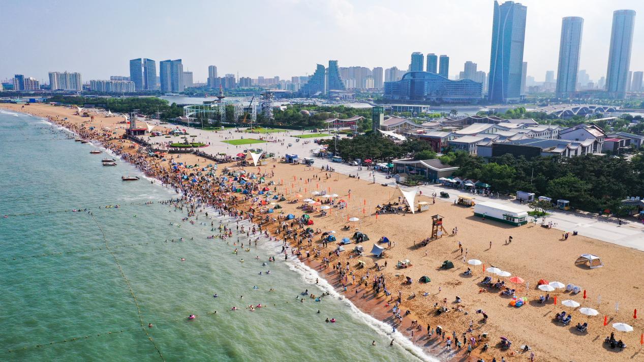 沙滩上游客如织，构成了一道独特的风景线。丁敏航 摄