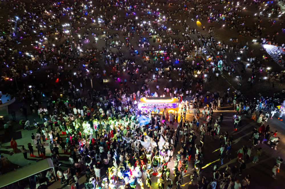 7月15日晚,游客在敦煌鸣沙山月牙泉景区参加万人星空演唱会(无人机照片)。新华社记者 郎兵兵 摄