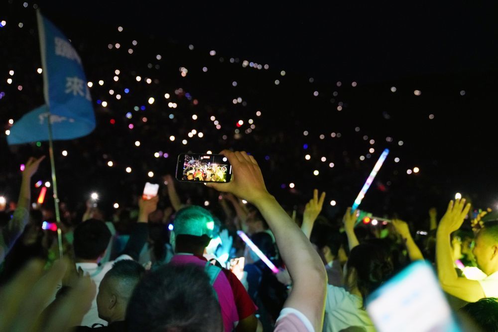 7月15日晚,游客在敦煌鸣沙山月牙泉景区参加万人星空演唱会。新华社记者 马宁 摄