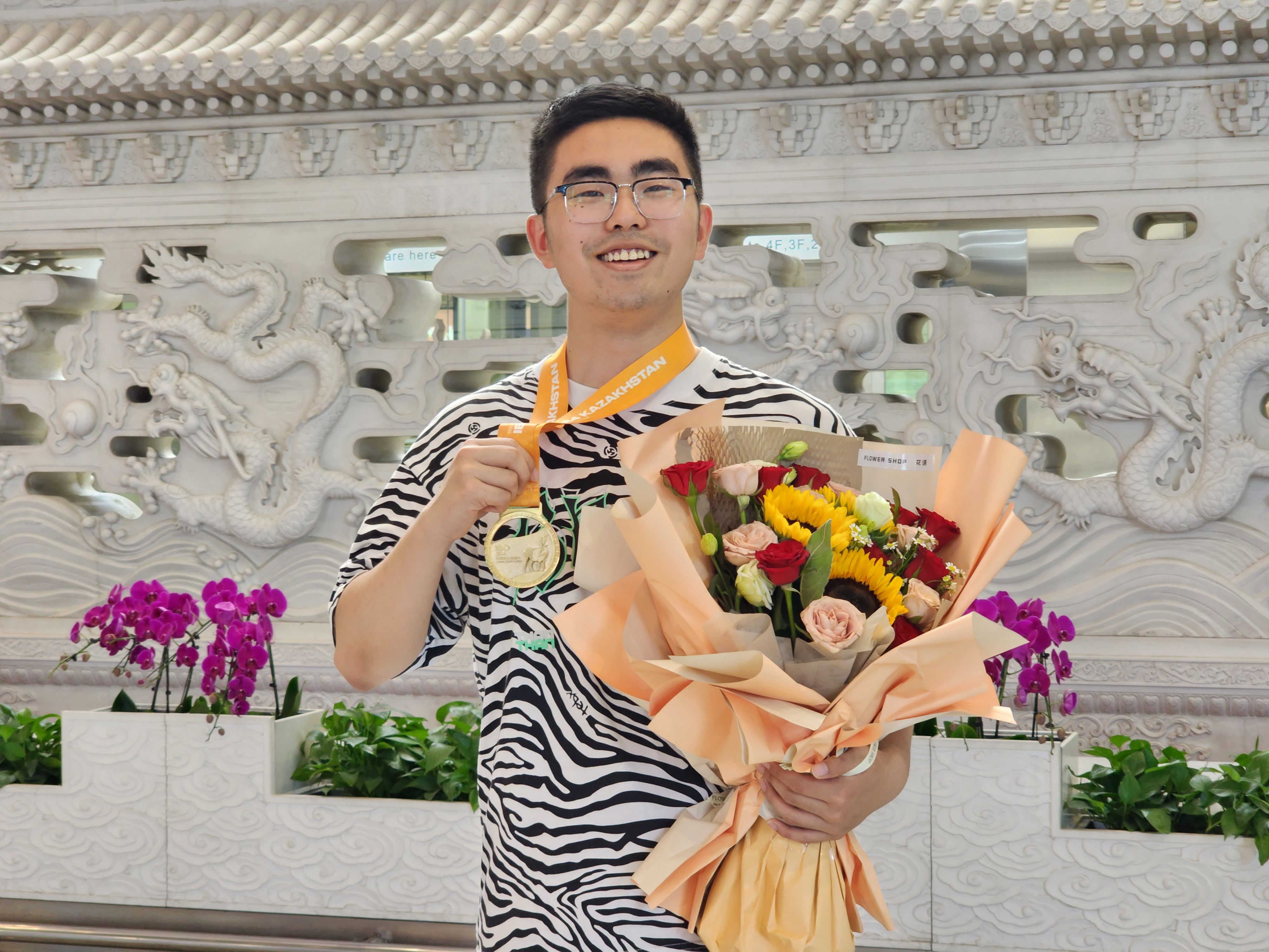 7月14日，在北京首都国际机场，王培昱展示夺得的国际生物奥林匹克竞赛金牌。 朱微 摄