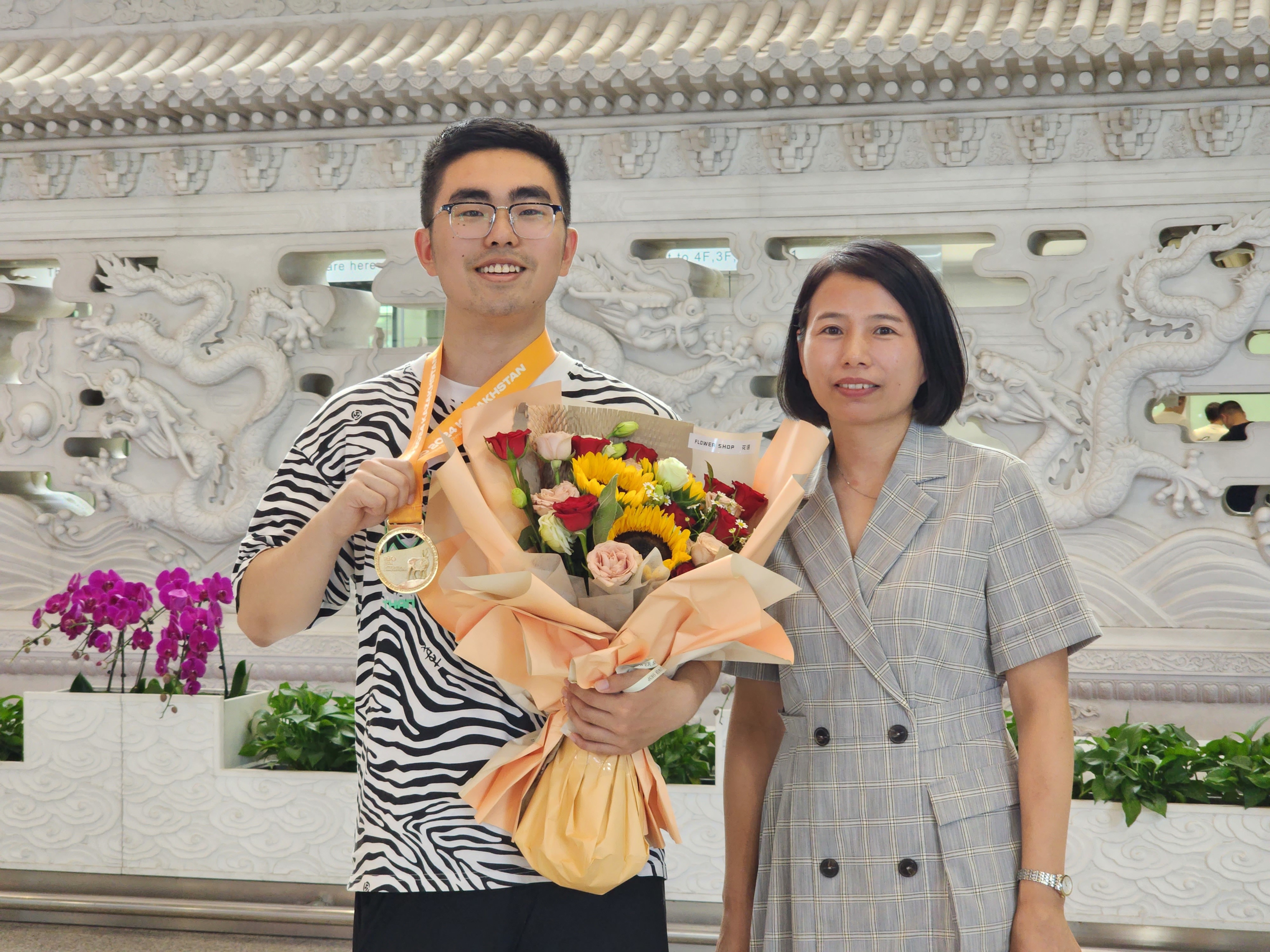 7月14日，在北京首都国际机场，王培昱（左）与前来迎接他的教练邢野合影。 朱微 摄