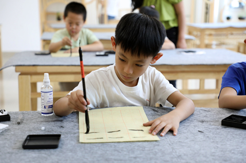 复兴大街小学暑期托管学生在书法教室学习书法