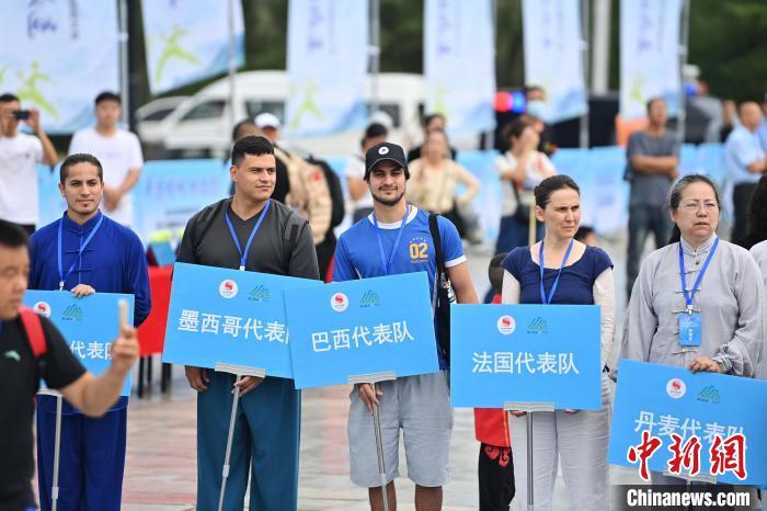 7月13日，“2024年北京体育大学第十五届国际武术比赛交流大会暨首届崆峒山国际武术大会”在甘肃省平凉市崆峒古镇开幕。此次活动有来自中国16个武术流派传承人，以及法国、丹麦、比利时、巴西、墨西哥、厄瓜多尔、古巴等国家60余名武术运动员和国内300余名参赛队员参加。图为国外代表参加开幕式。中新社记者　李亚龙　摄