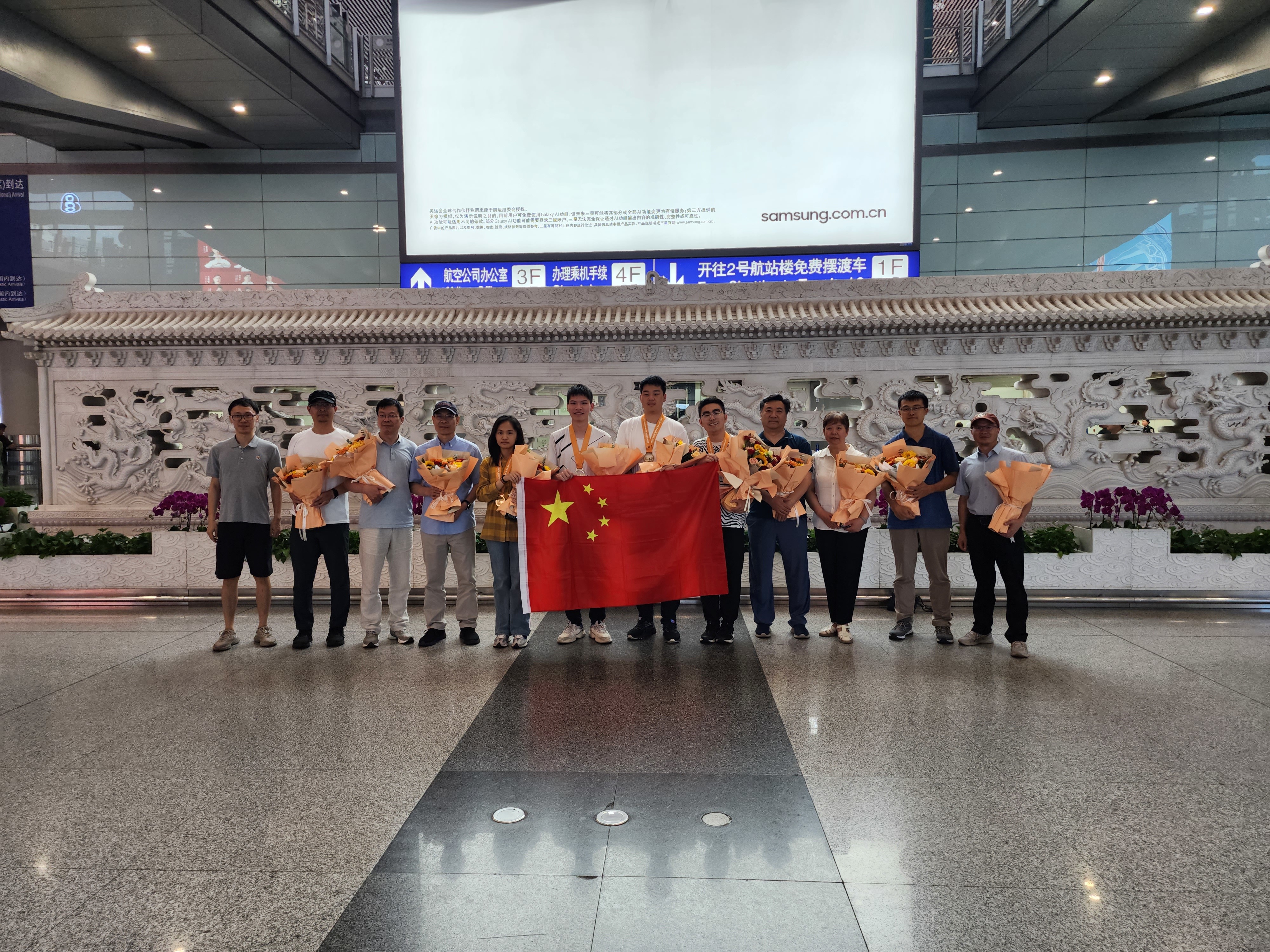 7月14日，在北京首都国际机场，王培昱（右五）等生物奥林匹克竞赛国家队成员与迎接的人们合影。 朱微 摄