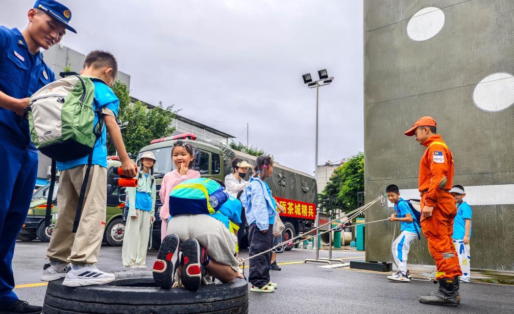 7月11日，在云南省普洱市森林消防营区，参加研学活动的学生体验滑轮在生活中的作用。新华社发（郭元首摄）