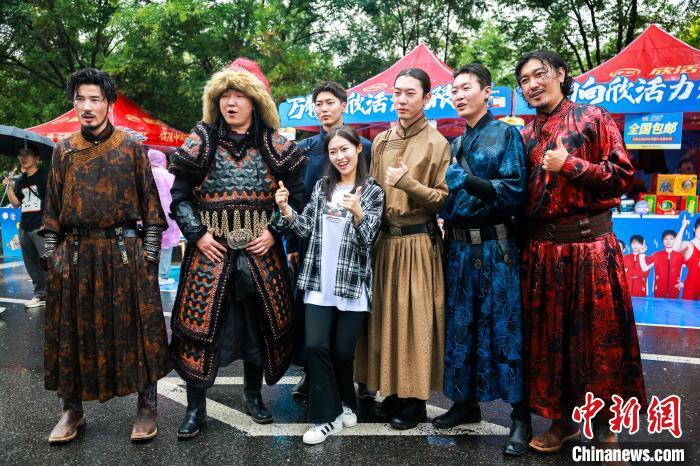 7月5日，薛之谦在呼和浩特开演唱会期间，歌迷与场外乌兰牧骑演员合影。　王劭凯 摄