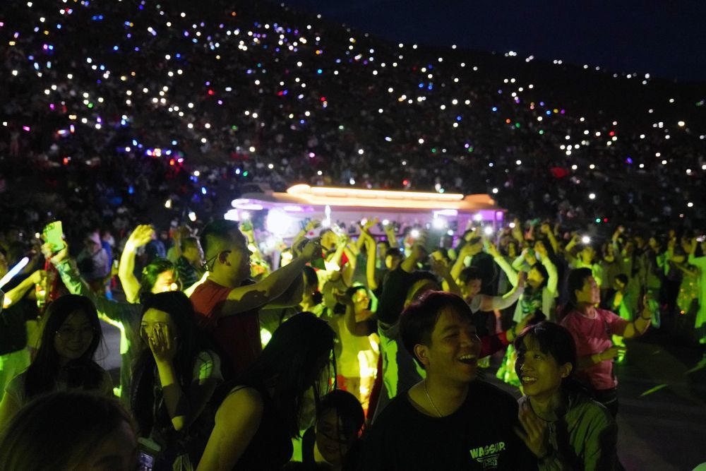 7月15日晚,游客在敦煌鸣沙山月牙泉景区参加万人星空演唱会。新华社记者 马宁 摄