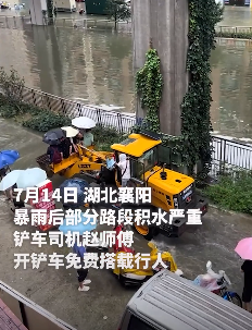 暴雨致路面积水 铲车司机免费搭载行人