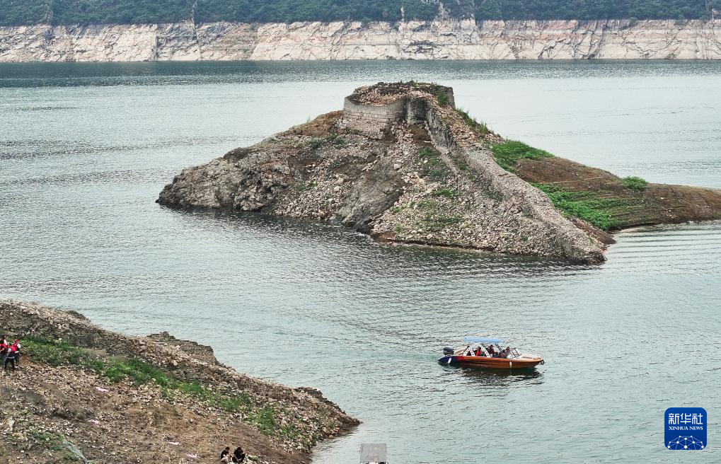 7月13日,在宽城满族自治县境内的潘家口水库,游客乘船欣赏露出水面的长城(无人机照片)。