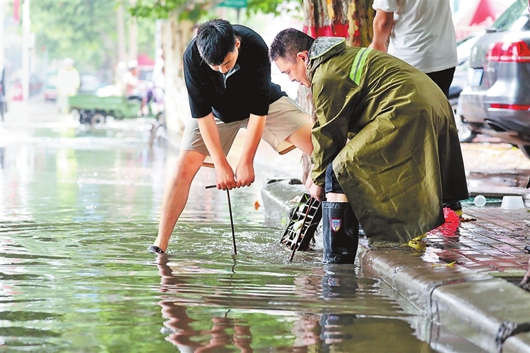 7月17日，温县住建局工作人员在疏通排水管道。徐宏星 摄